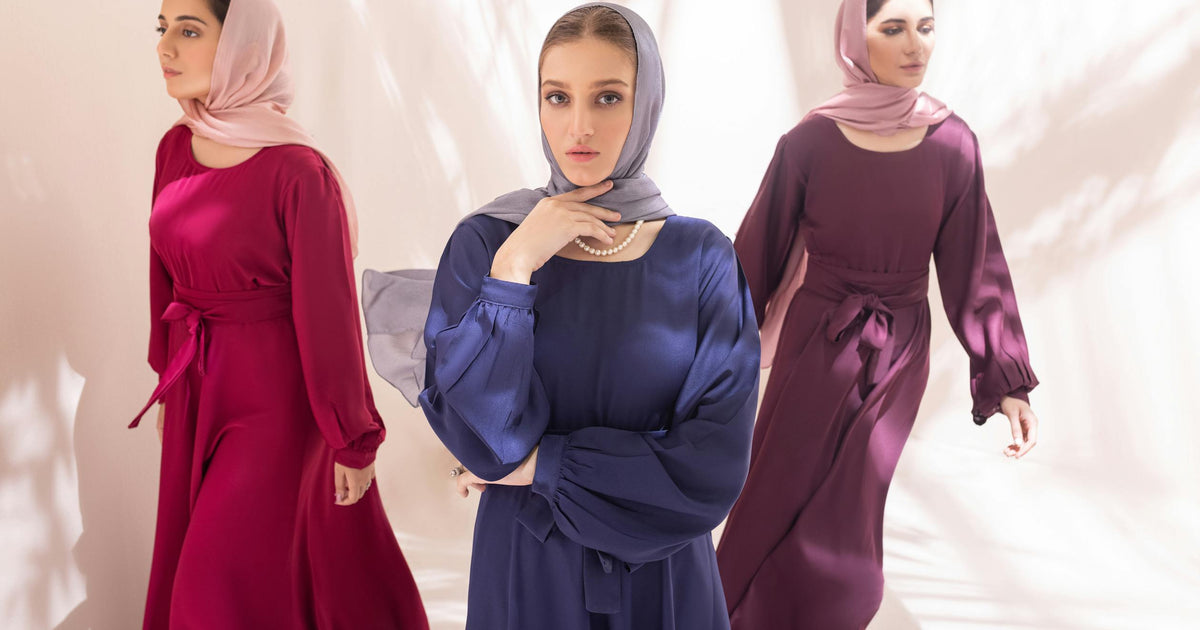 Three stylish women in elegant hijabs showcasing different colors in natural light