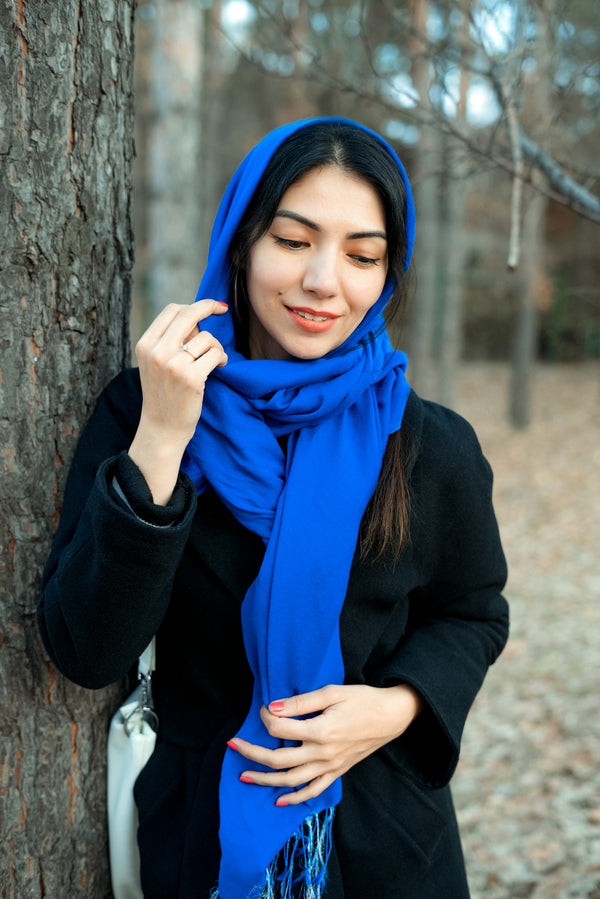 Woman wearing vibrant blue jersey hijab scarf outdoors in natural light